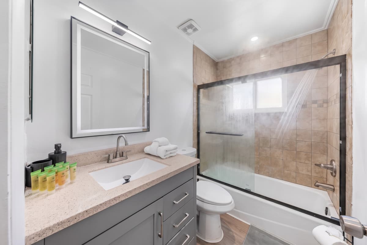 Contemporary lighting, sleek faucet hardware, and a spacious vanity bring hotel vibes to your stay.
