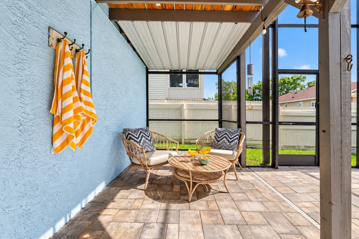 Stay cool under the covered patio, enjoy the ambiance of hanging lights, or dive into the pristine pool—all in your private, screened-in backyard sanctuary.