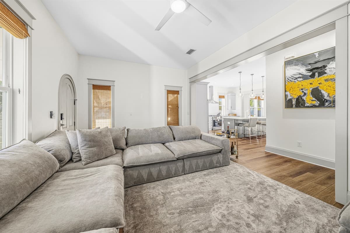 The open floor plan flows beautifully from the living room through an elegant arched doorway into the foyer. All-new finishes, hardwood floors, and fresh contemporary design throughout this brand-new Seminole Heights home.