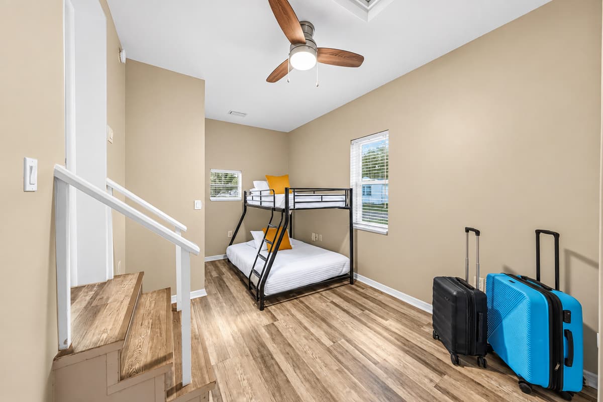 Bright bunk room with multiple beds and luggage space—ideal for larger groups or families.