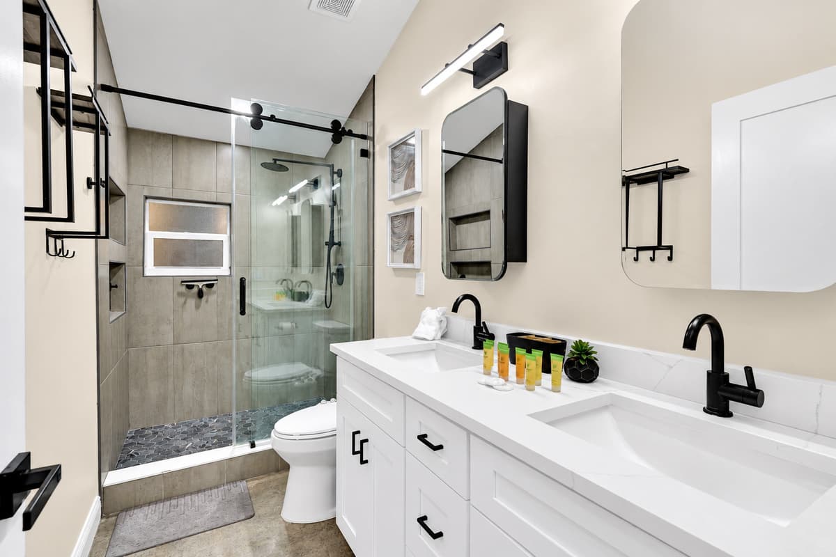 One of 7.5 bathrooms. This one has no queue. Glass shower, wide vanity and marble-look walls, with space for two people's things. On a trip this size, a bathroom to yourself is the real luxury.
