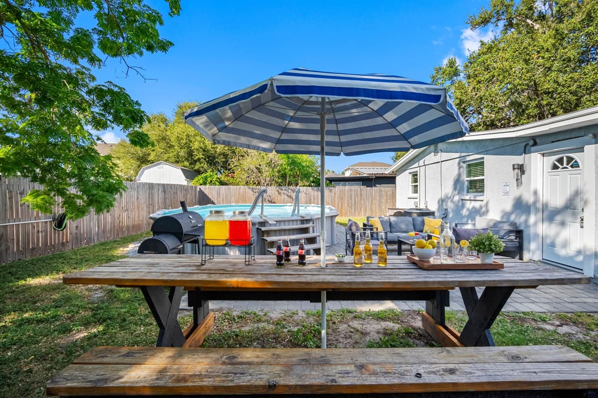 Enjoy meals al fresco at the picnic table shaded by a striped umbrella.