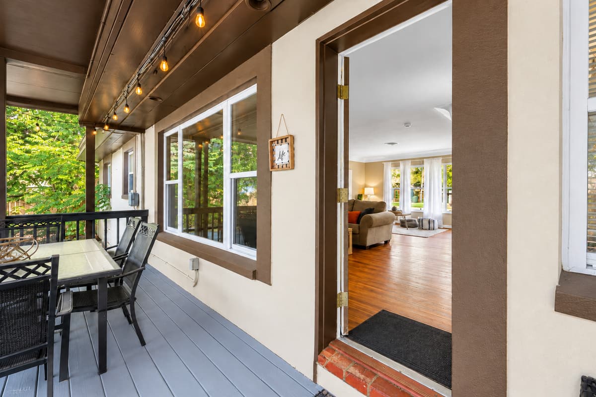 Covered patio entrance with outdoor dining space and seamless indoor-outdoor living.