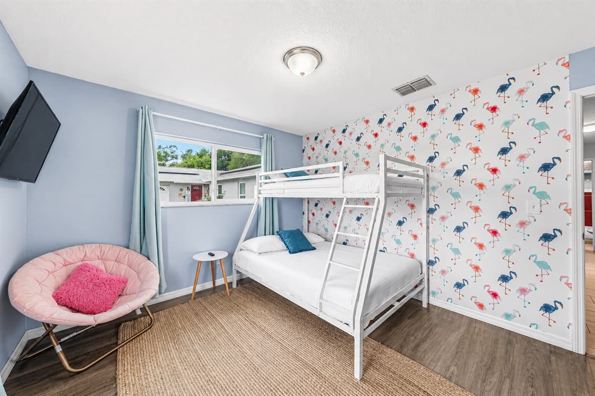 Fun and colorful bedroom featuring bunk beds and playful flamingo-themed décor—perfect for kids or groups.