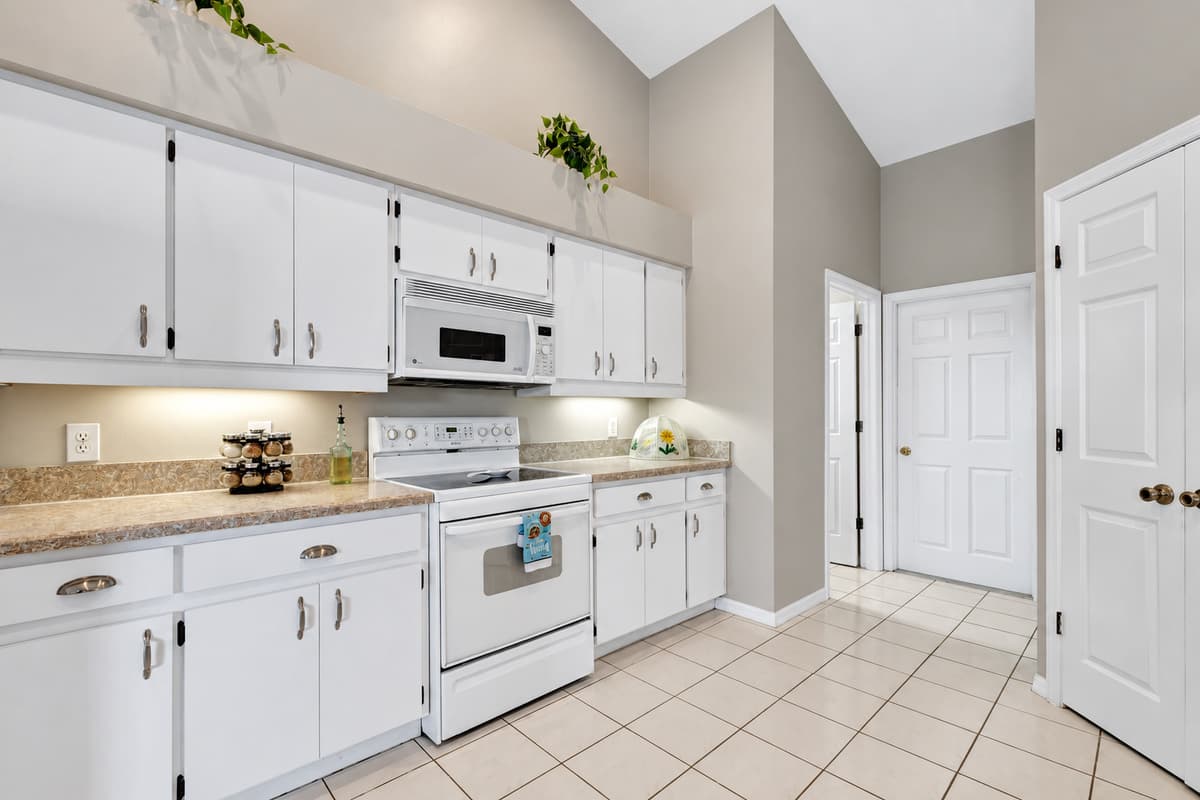 Come and experience the allure of our kitchen, where the white wooden cabinets, gleaming appliances, complete utensils, and the light-filled ambiance create an atmosphere that is both captivating and inspiring. 
