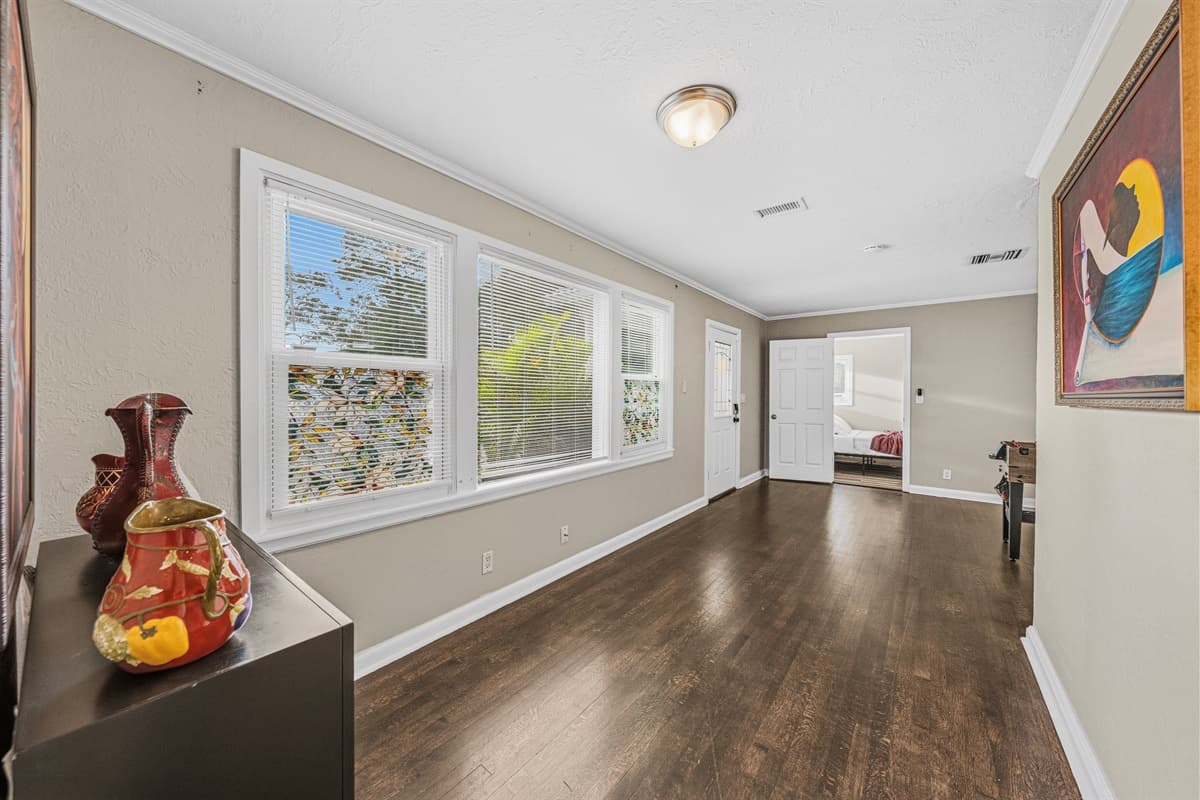 Bright hallway with large windows bringing in natural light and connecting living spaces.