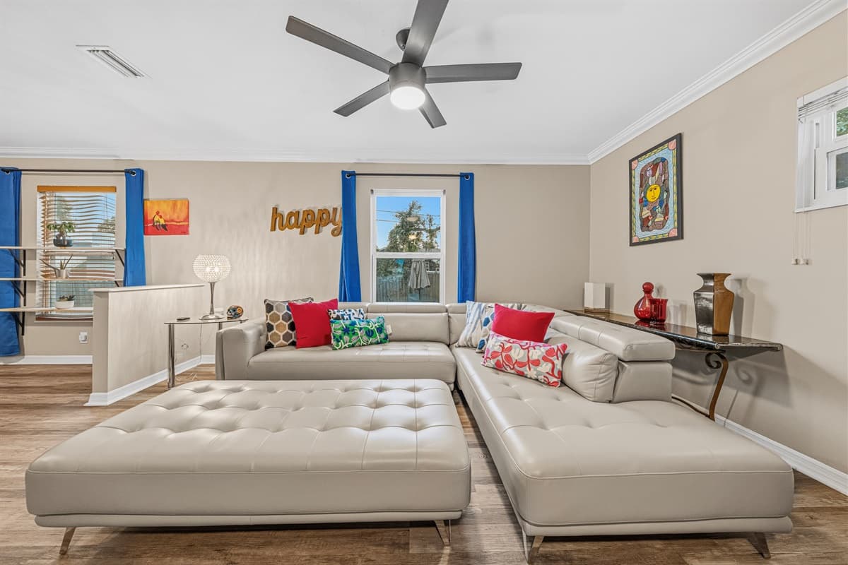 Comfortable living room with plush sectional, large TV, and vibrant accents for a cozy stay.
