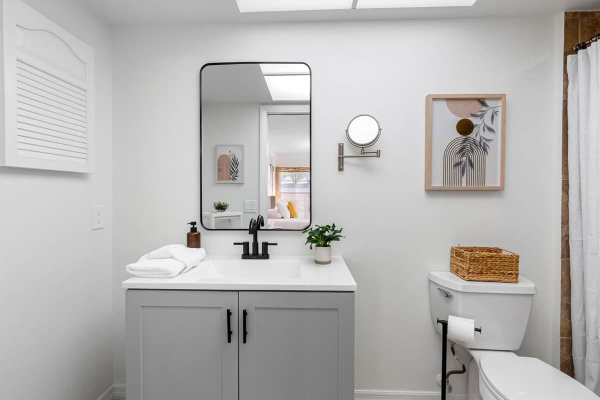 A modern vanity with matte black fixtures, and thoughtful storage for towels and toiletries. Clean, fresh, and calming.