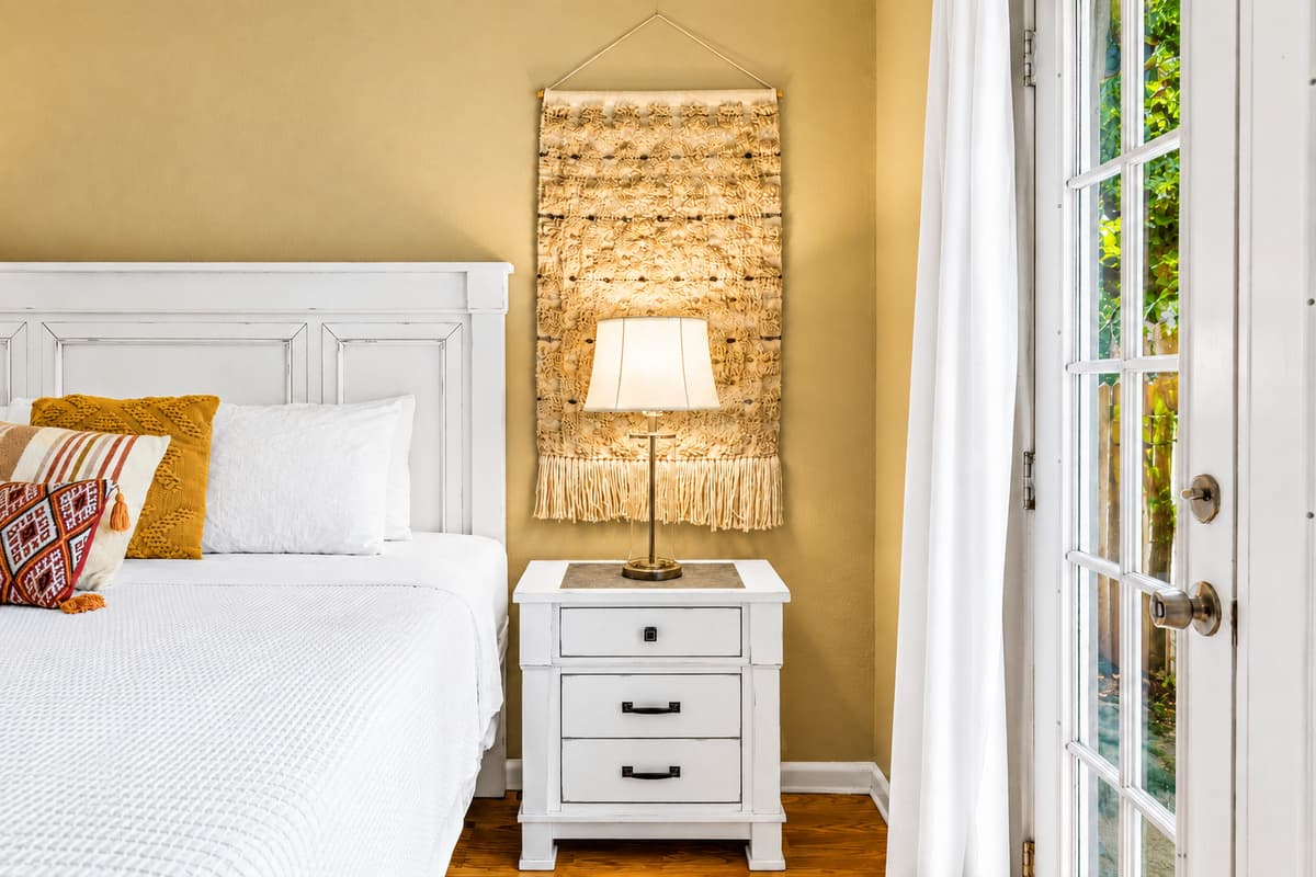 Cozy bedside view showcasing warm lighting, elegant décor, and peaceful outdoor access.