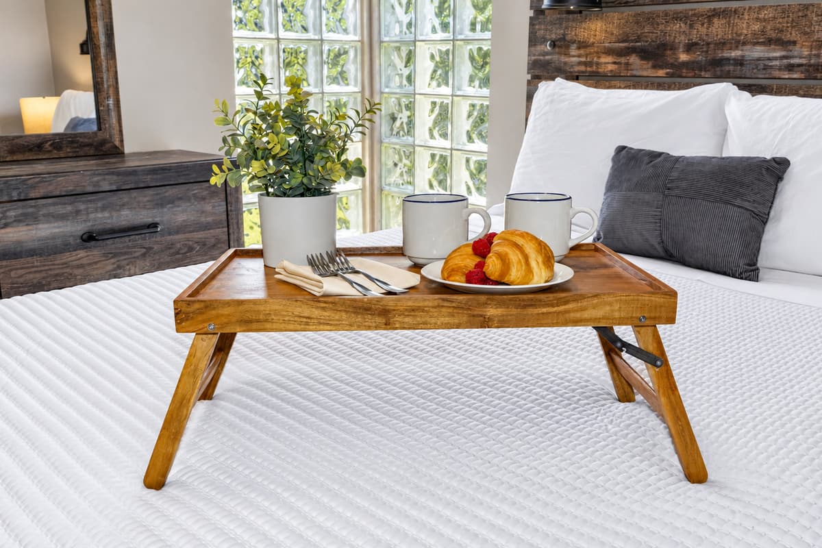 A blend of rustic wood finishes and sleek modern design creates a stylish yet comfortable bedroom retreat.