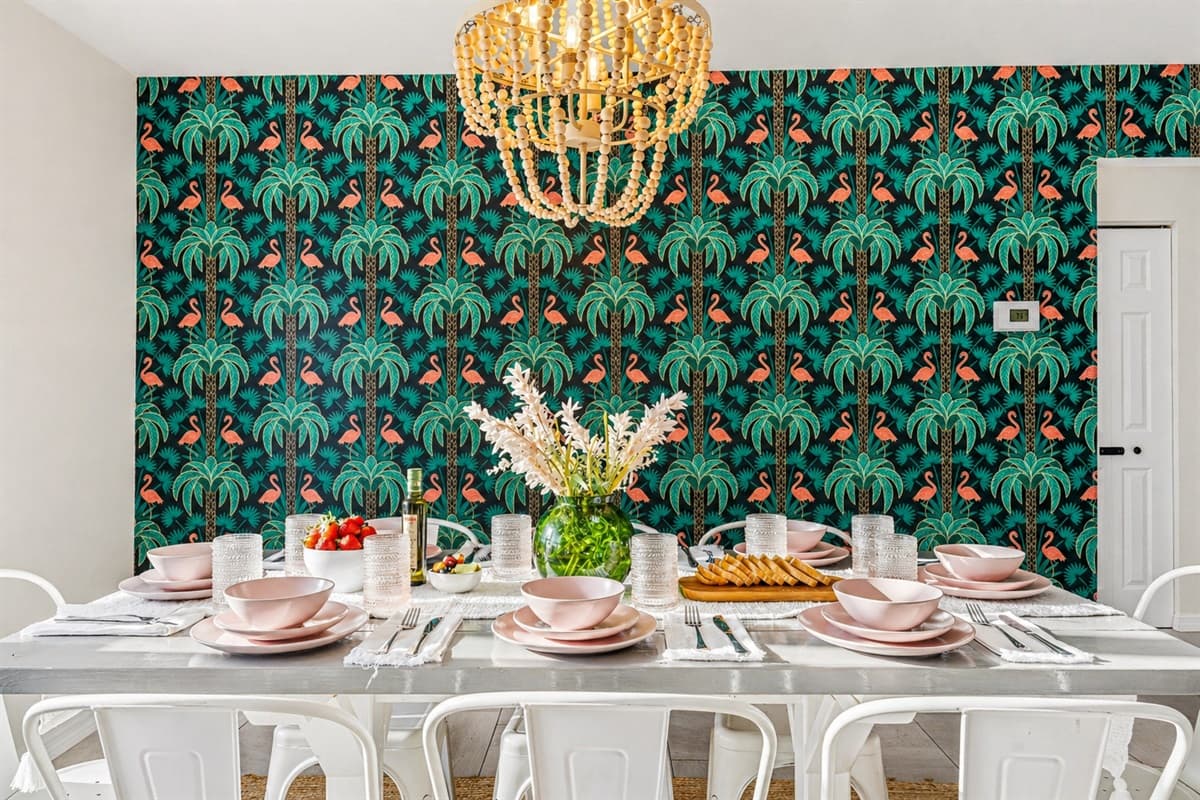 Statement dining wall with bold tropical wallpaper and elegant table setup. (Table setting for staging purposes only)