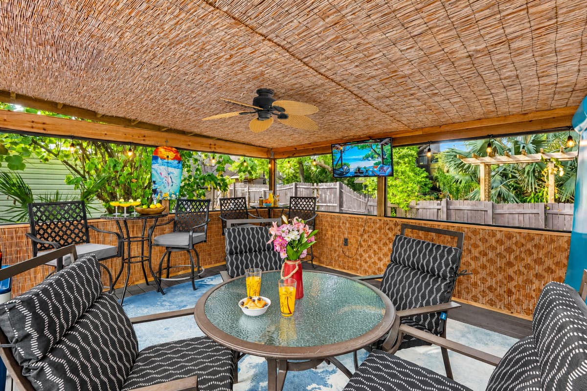 This thoughtfully curated patio oasis blends comfort and entertainment with a tropical ambiance.