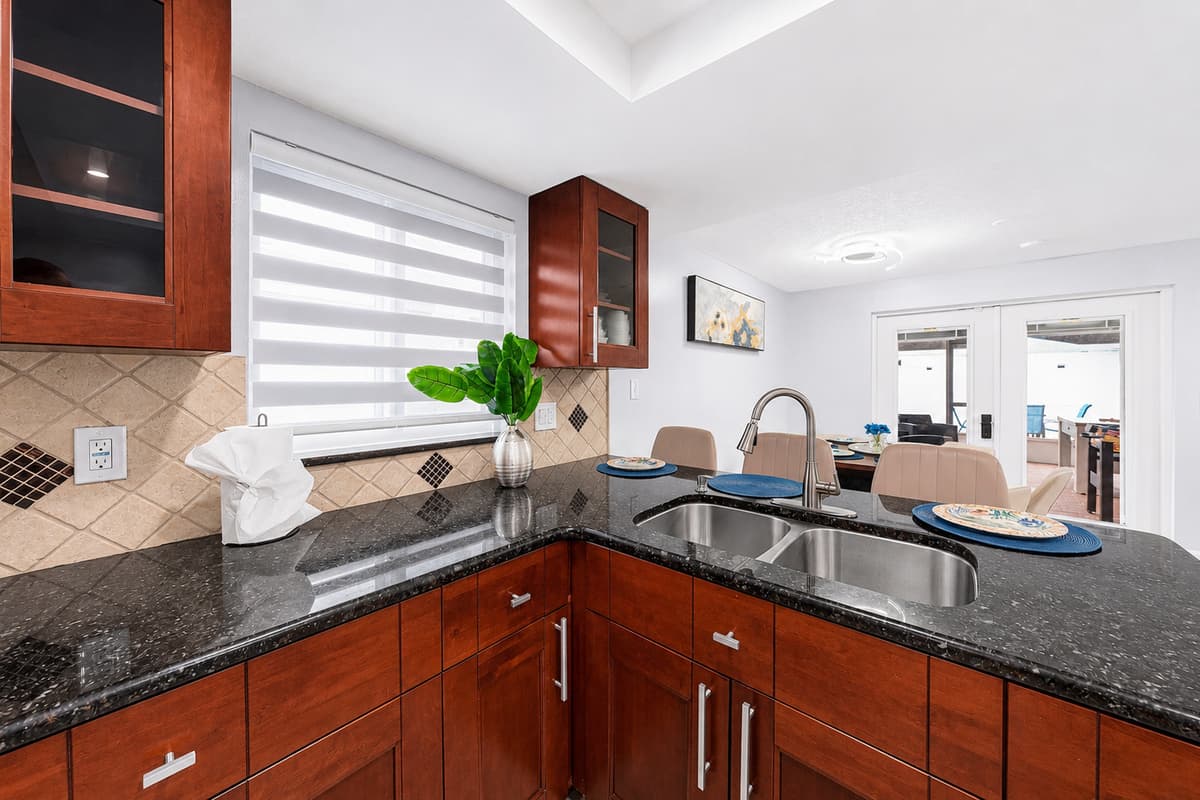 Modern kitchen featuring granite countertops, stainless steel appliances, and ample workspace for preparing meals during your stay.